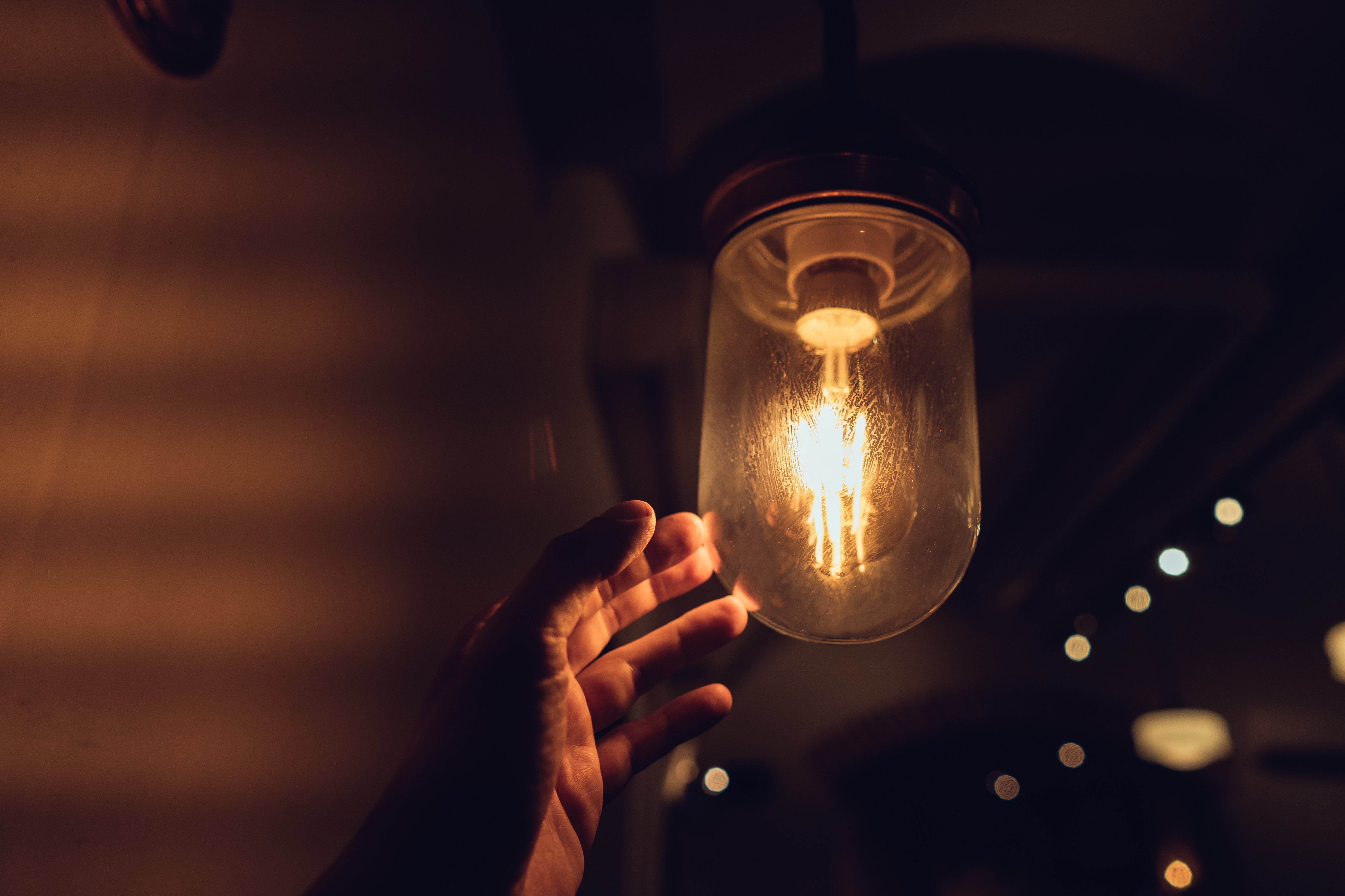 hand-reaching-vintage-light-bulb